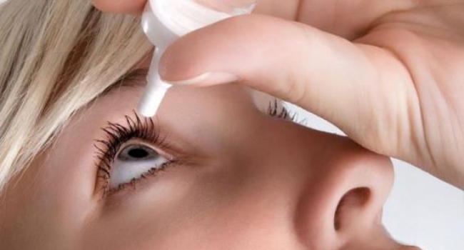 woman applying eye drops