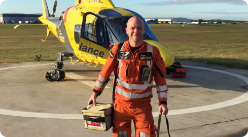 air ambulance doctor stands in front of helicopter